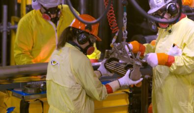 Workers load fuel into a nuclear reactor