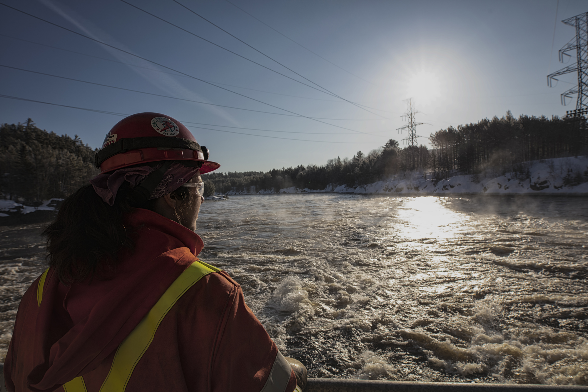 An water manager assesses water conditions near a hydroelectric dam.