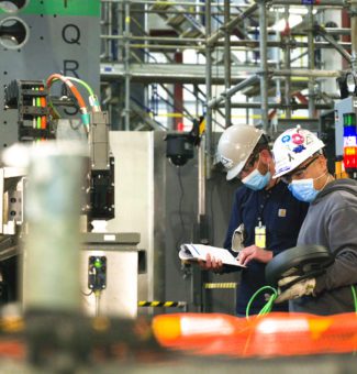 Workers in hard hats and masks perform work on OPG's Darlington Refurbishment project.