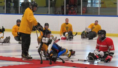 Puck drop at the a 2023 Parasport Sledge Hockey game.