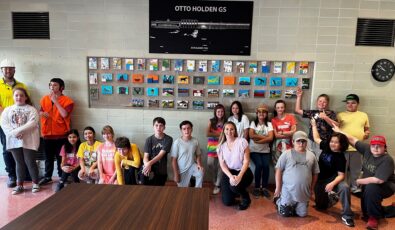 Grade 5/6 students from Mattawa District Public School pose in front of their artwork at Otto Holden GS.