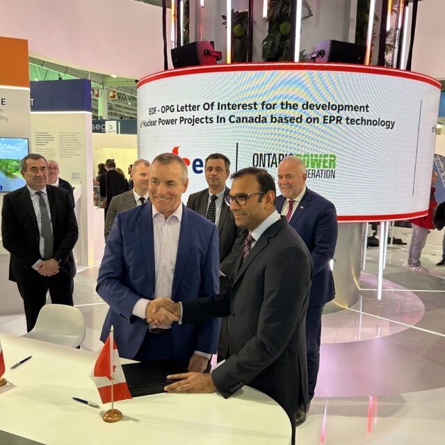 OPG's CEO, Ken Hartwick, shakes hands with representatives from France's EDF electricity company.