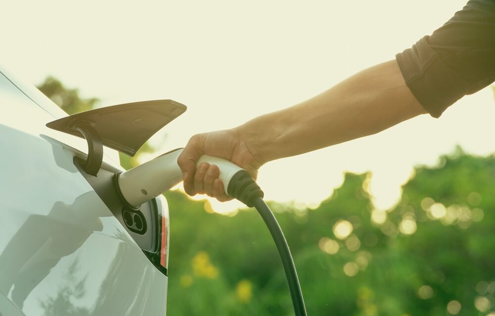 Man charging electric vehicle